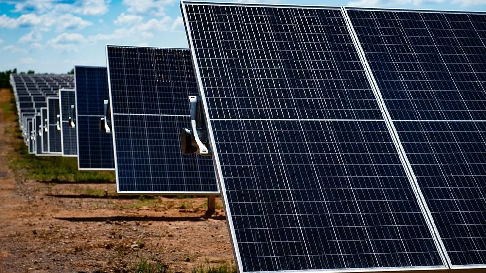 Filas de paneles solares de una planta a gran escala bajo el cielo